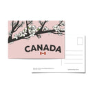 Canada postcard with an illustrattion of a cherry blossom branch and the word 'Canada' with a Canadian flag on a pink background.